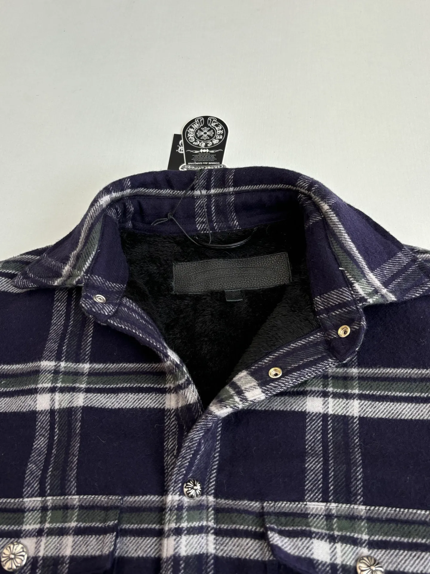 P670 Chrome Heart*/Chrome Heart Contrast Plaid Lapel Shirt Jacket. The fabric is made of 100% cotton fabric to create a navy blue main tone plaid. The rough plaid lines blend into the brand's iconic Gothic rebellious gene. The stiff cotton material supports the street silhouette, and the plush fabric inside adds softness and warmth. The collision of cold silver hardware and soft and warm inner wear is the dark aesthetic of Chrome Hearts' "symbiosis of hard core and gentleness". The autumn and winter layering has its own rock and roll accent.  Size：S/M/L/XL